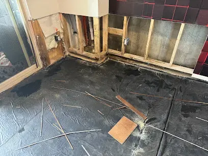 Bathroom walls cut away at the bottom and wet flooring pulled up for drying