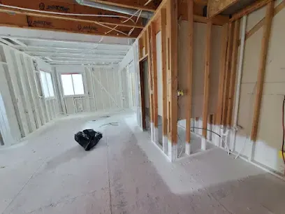 A bright room gutted to the studs, ready for drying equipment after a leak